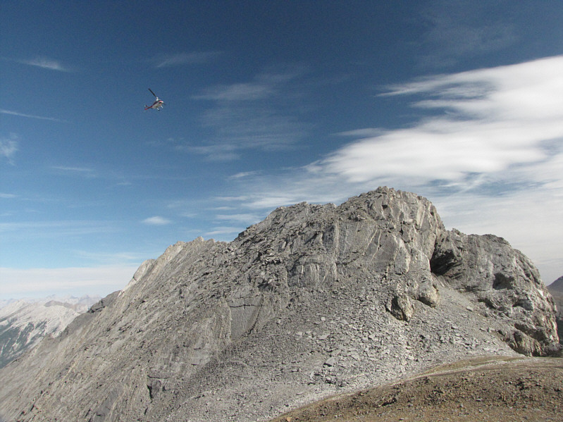 Only seconds earlier, another helicopter flew by barely skimming above the crest of the col.